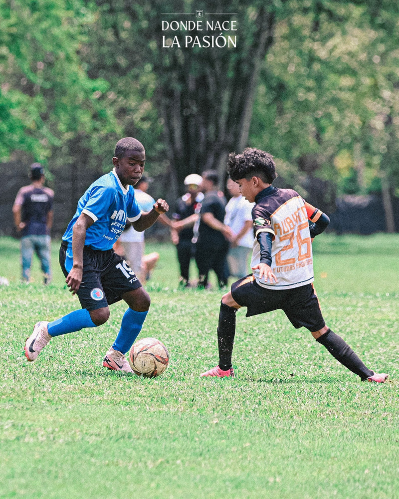 Dos jugadores de la Academia del América de Cali disputan el balón en un partido en La Candela